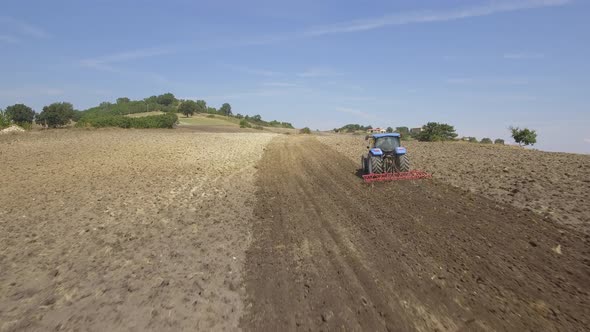 Farmer on tractor plowing a field in Umbria, Italy