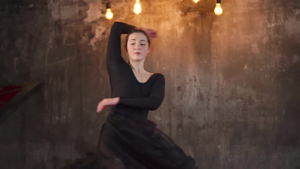 Performance of a Modern Dancer Woman in a Dark Gloomy Hall Wth Bulbs