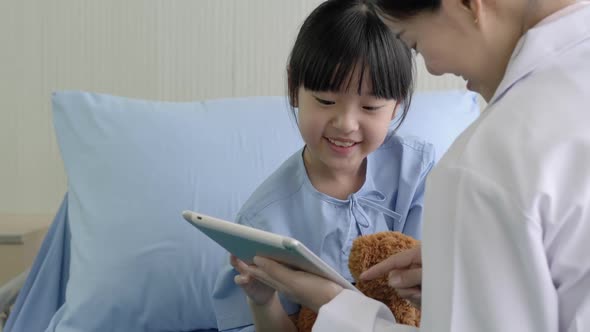 Doctor pediatrician and girl with tablet