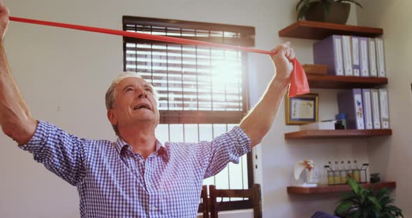 Senior man exercising with resistance band 4k