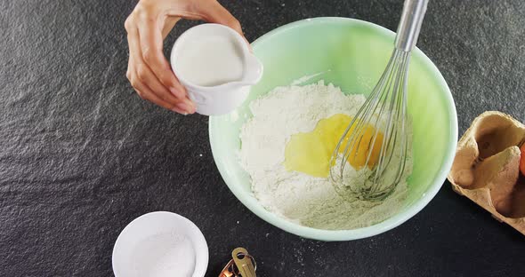 Woman mixing milk in flour 4k