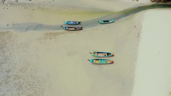 Aerial view or top view of long-tailed boat is floating on the emerald sea. Calm andaman sea at Phuk