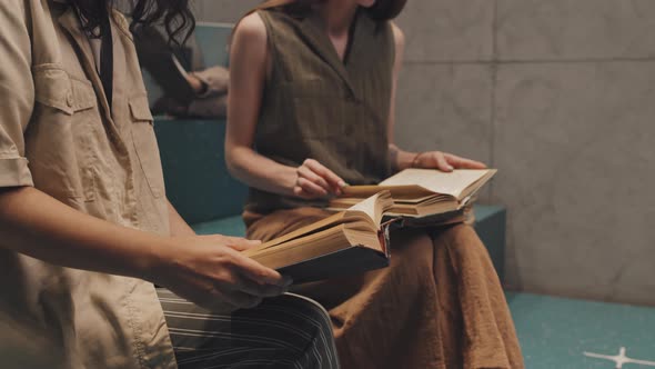 Female Students Studying with Books on Stairs