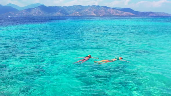 Beautiful ladies happy together on tranquil coast beach vacation by blue lagoon with white sandy bac