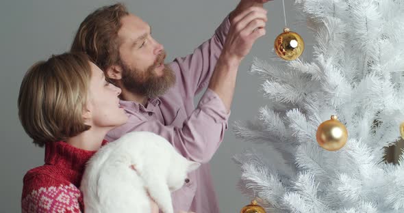 Family Girl and Guy Two Friends with White Cat Pet Together Celebrate New Year Preparing for Holiday