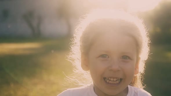 Little Girl Runs and Back Sunlight Creates Halo Around Hair