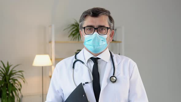 Portrait of a Senior Doctor in White Suit and Protective Mask