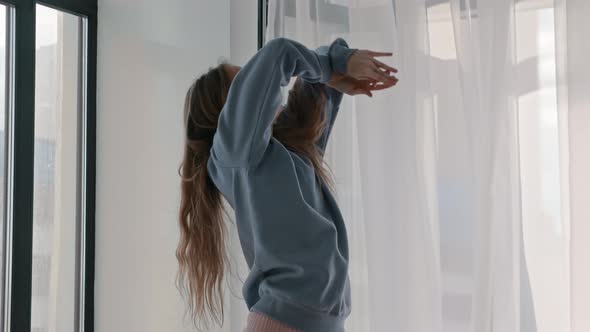 Young Woman in Pastel Clothes Performing Modern Dancing By the Window