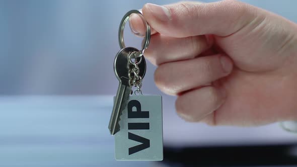 VIP Inscription on Keychain in Businessman Hand, Luxury Resort for Rich Customer