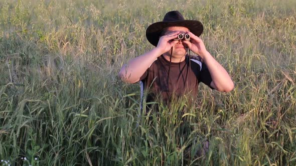 Young traveler man holding binoculars on the mountains