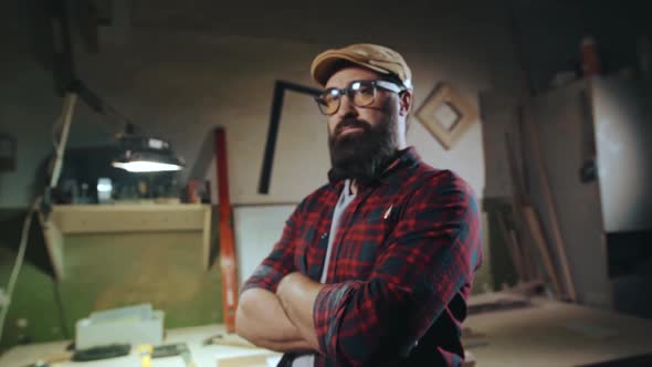 Portrait of a Bearded Man in Glasses Who is Standing with His Arms Crossed