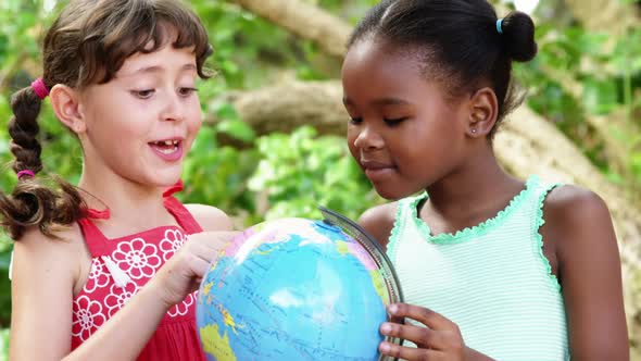 Schoolkids looking at globe in campus at school