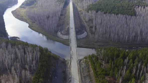 An Aerial View of a Road Bridge Over a River in the Forest.