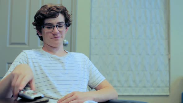 Teenager watching television in media room.