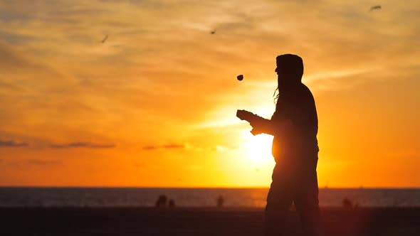 A Young Juggler on the Beach at Dusk