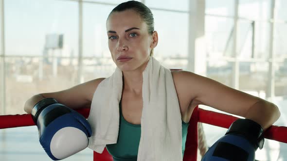 Slow Motion Portrait of Successful Boxer Resting in Ring Corner Wearing Gloves