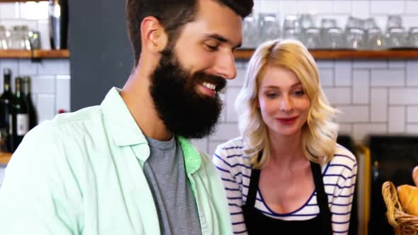 Portrait of waitress interacting with customer at counter