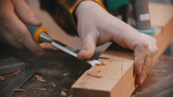 Woodworker Cutting Out the Recess on the Wooden Block with a Chisel