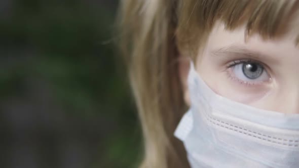 Little Girl in a Medical Mask. Eyes Close Up