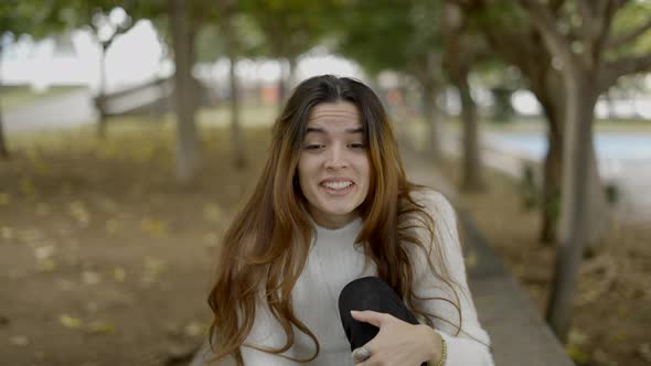 Young Darkhaired Woman in Park Smiles Into Camera Close Slomo