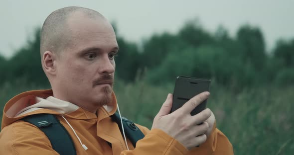 Man in Yellow Raincoat is Trying to Catch GPS or Internet in Nature