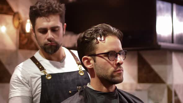 Male barber tying client apron