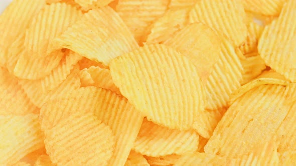 Looped Spinning Yellow Wavy Potato Chips Full Frame Closeup Background