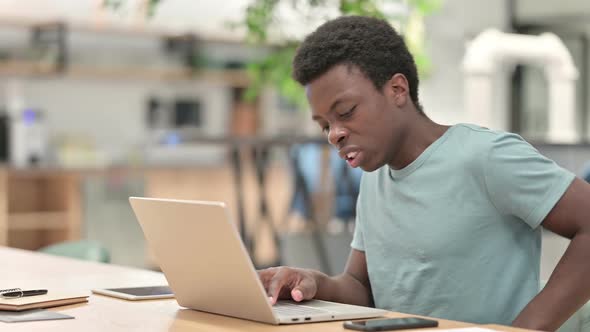 Young African Man with Laptop Having Back Pain