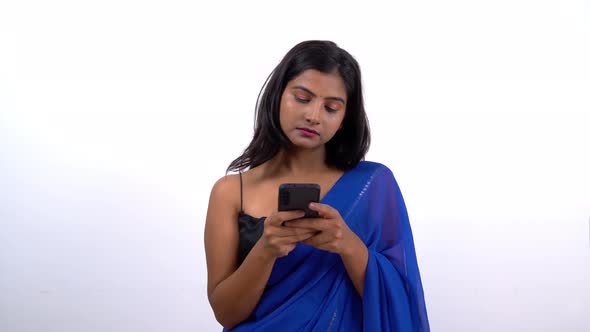 Indian woman in saree chatting with someone on a messaging app
