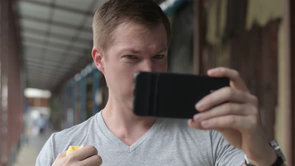 Face of Young Tourist Man Wiping Sweat and Using Phone As Mirror at the Local Pier in Bangkok