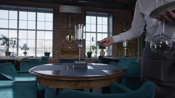 Unrecognizable Male Waiter Setting Reserved Table in Luxurious Restaurant Indoors in Slow Motion