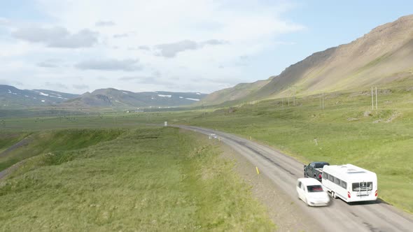 Campervan Being Towed On Rural Road By A Pickup Vehicle In Westfjords, Iceland. aerial following