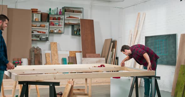 Middle Aged Carpenters Build a Solid Wood Wall in a Carpentry Workshop Carpenters Measure the
