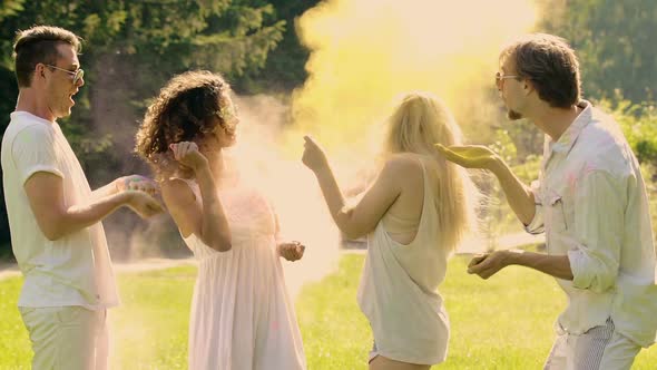 Excited Friends Playfully Fighting With Colorful Powder, Having Fun at Party