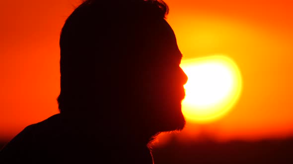 Silhouette of man with beard wearing disposable mask. Face in a protective mask