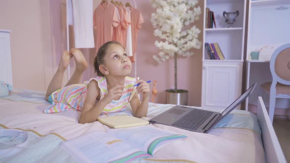 Thoughtful little girl doing homework at home. alt