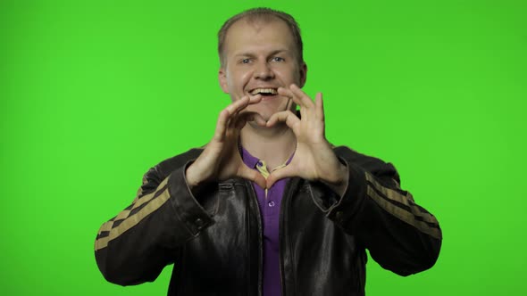 Brutal Rocker Man Taking Out Heart Gesture From His Jacket and Demonstrating Romantic Emotions