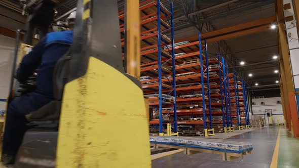 Loader Rides Along the Warehouse