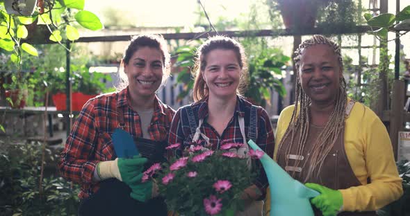 Multiracial women working together inside nursery greenhouse - Green market concept
