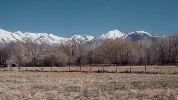 Sweeping panorama of the snowcapped rocky mountains, fields, and meadows on a clear winter or autumn