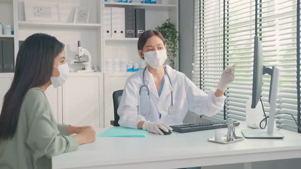 Professional female physician wear mask, use laptop computer and advise treatment plan to sick women