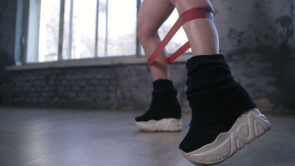 Legs of Sporty Woman Exercising with Elastic Band