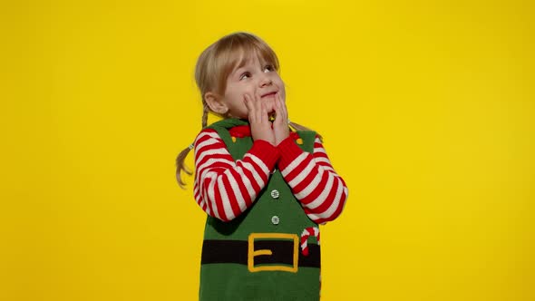 Christmas wish concept, kid teen girl in Christmas elf Santa helper costume making a wish, prays