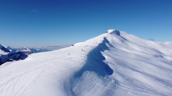 a snow-capped mountain peak in Bern, filmed with a drone, beautiful perfect sunny weather