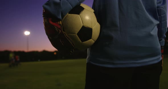 Female soccer player holding the ball on soccer field. 4k