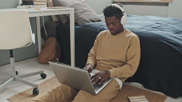 African American Man Working on Laptop in Bedroom