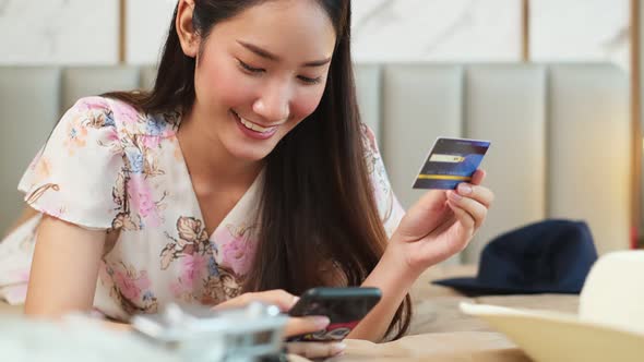 Smiling woman with laptop or tablet and credit card at home.