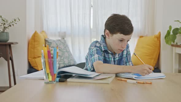 Young boy sitting at home preparing homework for school