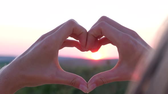 Show Hand Gestures Heart on Pink Sunset Background Love and Health Concept