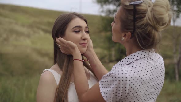 Mother Touching Face and Hair of Adult Beautiful Daughter. Portrait of Charming Brunette Caucasian